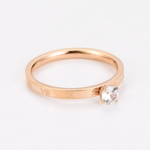Macro detail of rose gold ring featuring Roman numerals and a round-cut clear zircon