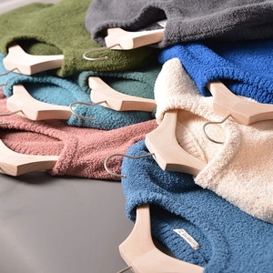 Close-up of stacked colorful knit sweaters on hangers showing texture and vibrant colors