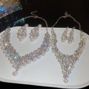 Détail de l'élégant ensemble collier et boucles d'oreilles perles avec strass brillants