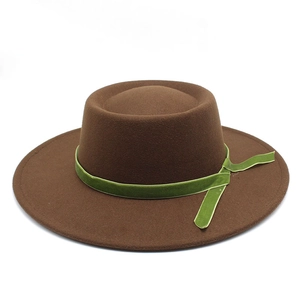 Detail of dark brown wool felt hat featuring a vibrant green velvet ribbon band