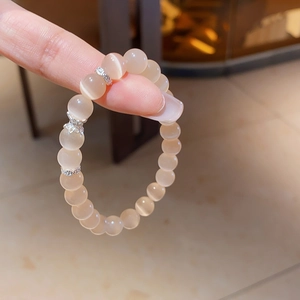 Vue macro d'un bracelet en perles œil de chat rose avec des entretoises argentées