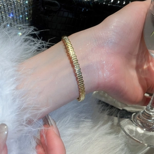 Detailed close-up of 18k gold plated bracelet with textured segments and elegant zircons