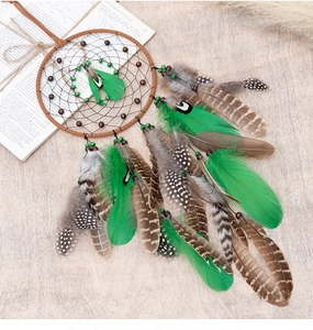 Detailed view of bohemian dream catcher with brown woven rings and natural feathers