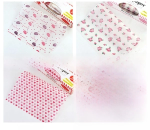 Macro detail of wax paper sheets with macaron, rose and heart patterns for food wrapping