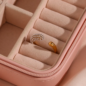 Macro view of a gold open ring with small pearls and teardrop design in a pink case