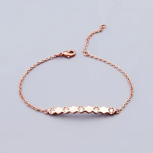 Macro detail of rose gold geometric hexagon bracelet featuring shimmering cubic zirconia