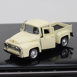 Detailed view of cream vintage alloy pickup truck model with open doors on black surface