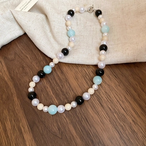 Detailed shot of multi-colored pearl and glass beads necklace with silver metal clasp