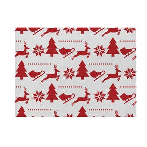 Close-up of red and beige linen Christmas placemat with reindeer and snowflake patterns