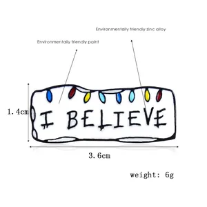 Detail view of I BELIEVE enamel pin with colorful bulbs, size 3.6cm by 1.4cm