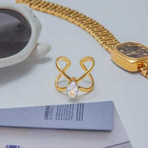 Detailed close-up of gold-plated X-shape ring with a marquise-cut zircon stone