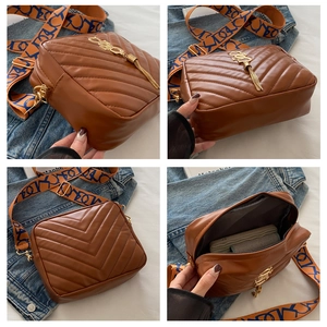 Detail view of brown quilted crossbody bag with gold tassel, logo and patterned strap