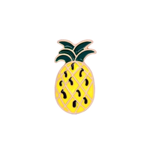 Macro detail of a yellow enamel pineapple brooch with green leaves and gold edges