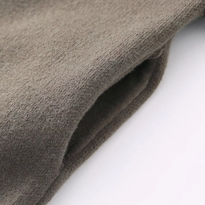 Macro detail of high-density fine knit fabric texture and pocket stitching in tan