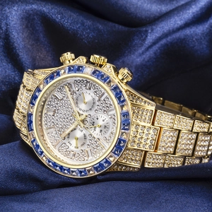 Macro detail of luxury gold watch with sparkling crystals and blue gemstone bezel