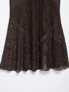 Detailed close-up of dark brown lace hem featuring intricate floral mesh patterns