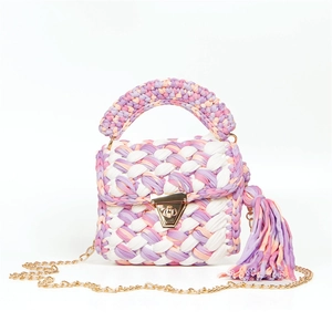 Detail of handmade woven bag featuring colorful fabric strips and golden metal lock