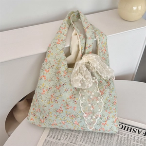 Detailed shot of floral canvas tote bag with a white lace bow and vintage newspaper background