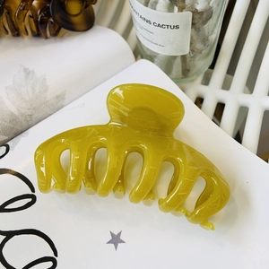Detail of neon green large flower hair claw clip with glossy resin finish for long hair