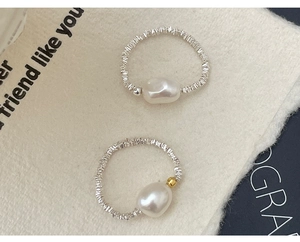 Macro view of S925 silver rings with natural pearls and contrasting gold accents