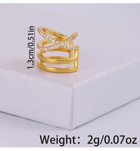 Détail macro d'une bague croisée dorée multicouche avec zircons blancs sur support blanc