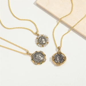 Vintage gold and silver coin necklaces with embossed pendants and emerald gemstone accents