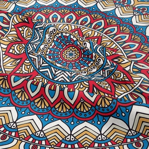 Detailed view of bohemian mandala fabric with intricate red and blue geometric patterns