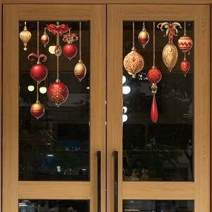 Christmas window decals featuring red and gold ornaments on a wooden glass door