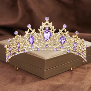 Detail of golden Baroque crown with purple teardrop crystals and rhinestones in gift box