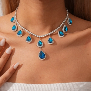Détail du collier vintage avec pendentifs goutte d'eau bleue et strass sur modèle
