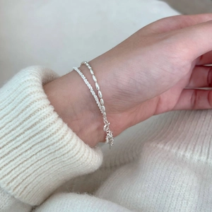 Close-up of double-layer S925 sterling silver bracelets with fine beads on a wrist