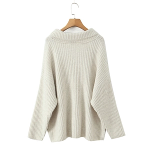 Detail eines beige Strickpullovers mit Rippmuster und modischem Reverskragen für Damen