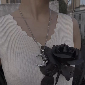 Detailed shot of gothic silver moon pendant with rose engraving on a model