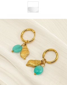 Detail of gold hoop earrings featuring textured shells and turquoise stone beads