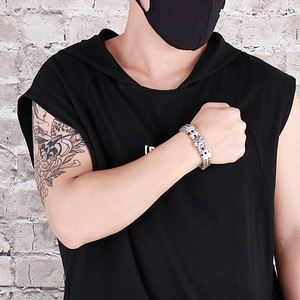 Rugged silver skull steel bracelet for men on tattooed wrist with streetwear vibe