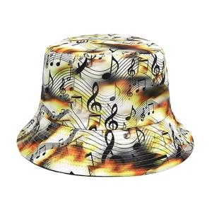 Detail of music note pattern on cream bucket hat with yellow tie-dye fabric