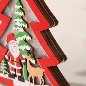 Detail view of multi-layer laser cut wooden Christmas ornament with Santa and reindeer