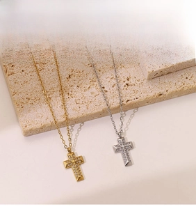 Detail shot of punk style cross necklaces in gold and silver finish with zircon stones