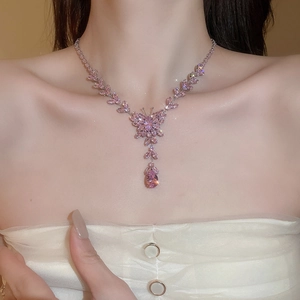 Detail of pink zircon butterfly necklace with water drop pendant worn by a model
