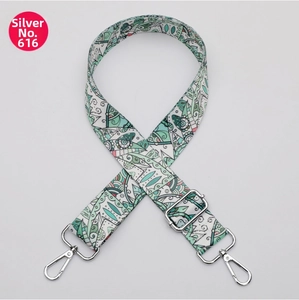 Close-up of bohemian style adjustable wide bag strap with floral print and silver clips