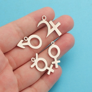 Macro shot of silver stainless steel charms with male female and zodiac symbols