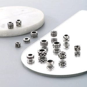 Detailed view of silver titanium steel beads with woven and geometric patterns for bracelets