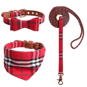 Three-piece red plaid dog collar with bow tie, matching leash, and bandana set