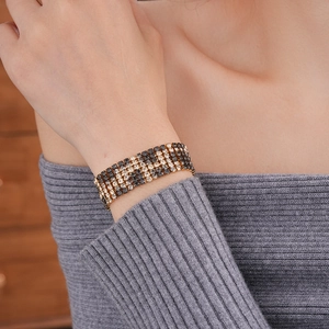 Detailed close-up of a wide multi-row black and white rhinestone bracelet on a wrist