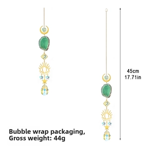 Detail of bohemian suncatcher with crescent moon, green agate slice and evil eye motif