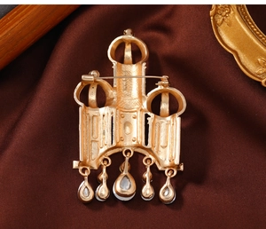 Macro view of vintage golden castle brooch back with mesh texture and hanging crystals