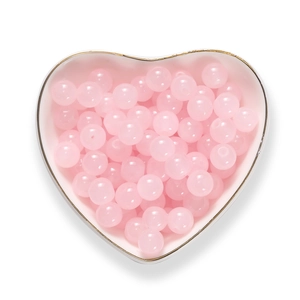 Perle di vetro rosa pastello traslucido per gioielli in un vassoio a cuore