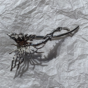Close-up of silver irregular liquid metal hair claw with aesthetic coral-like texture