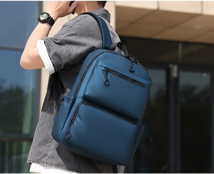 Dunkelblauer wasserabweisender Laptop-Rucksack mit vielen Taschen auf dem Rücken getragen