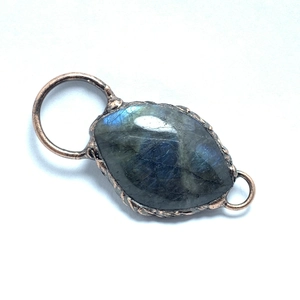 Close-up of labradorite stone pendant with blue flash in vintage copper double-loop frame
